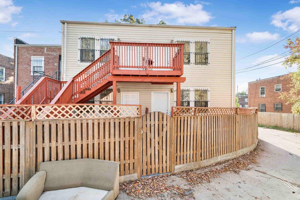 a house with a fence and a couch in front of it