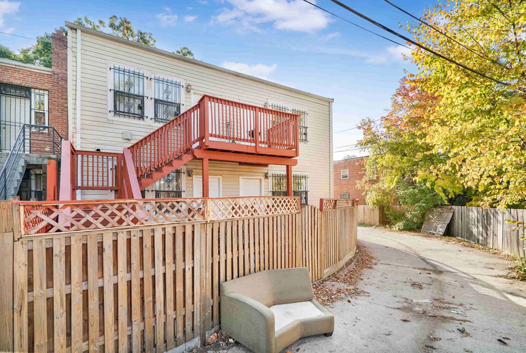 a white house with a fence and a chair in front of it