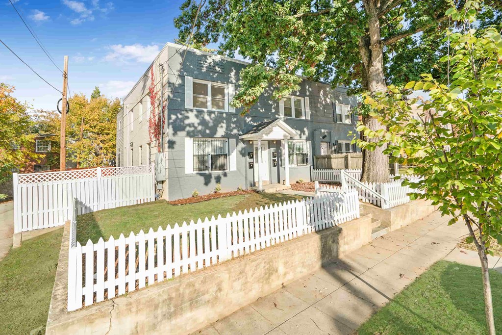 a blue house with a white fence in front of it