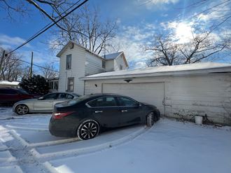 a car parked in the snow in front of a house