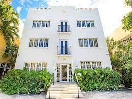 a white building with blue shutters and a staircase