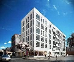 A white building with many windows is the main focus of the image.