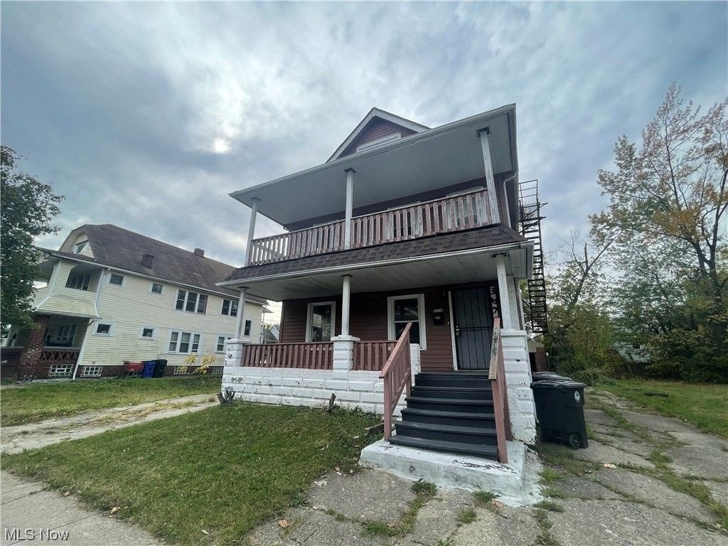 the front of a house with stairs and a porch