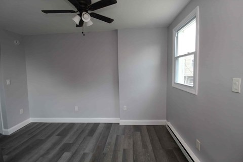 A room with a ceiling fan and a window.