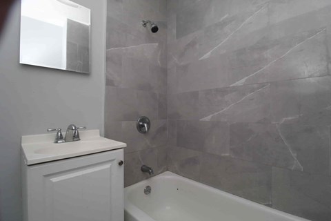 A white bathroom with a tub and sink.