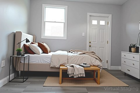 A bedroom with a bed, nightstand, and window.