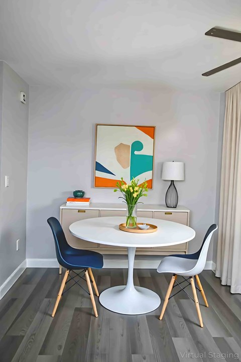 A dining room with a white table and blue chairs.