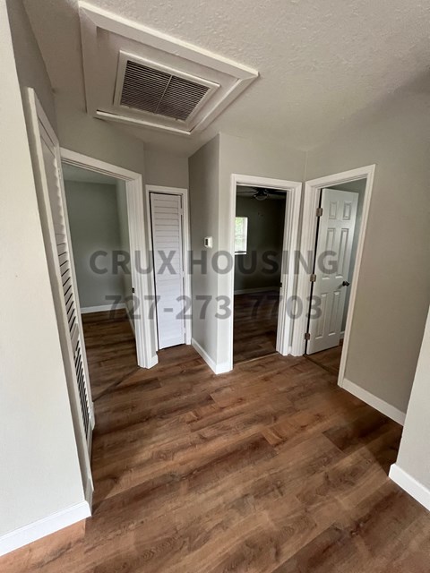 a renovated living room into a hallway with a wood floor