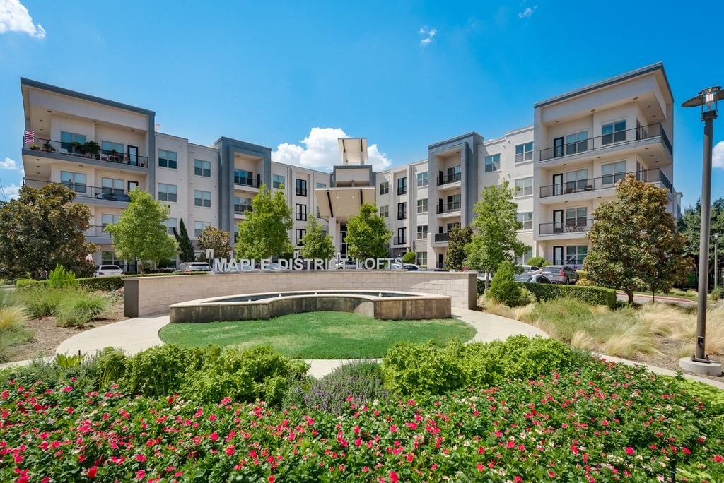 a park with a fountain in front of an apartment building