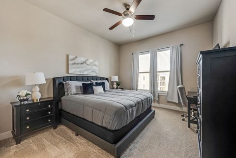 a bedroom with a bed and a ceiling fan