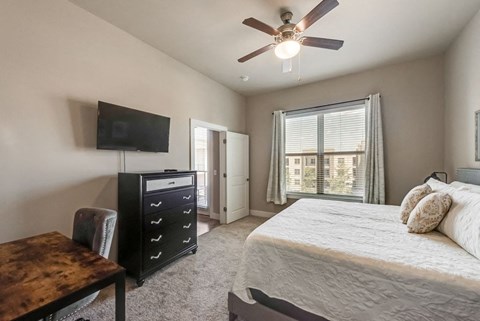 a bedroom with a bed and a ceiling fan