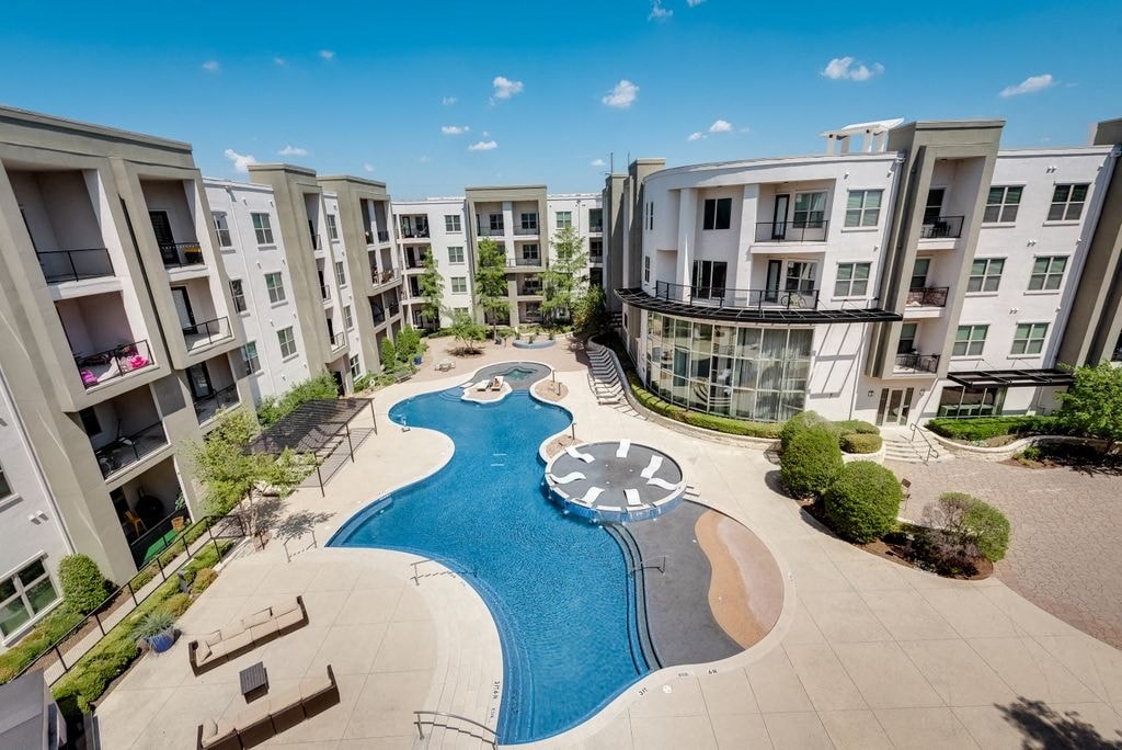 an aerial view of a swimming pool in front of an apartment building