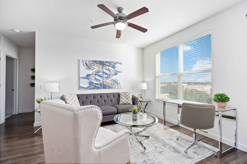 a living room with a couch and a ceiling fan