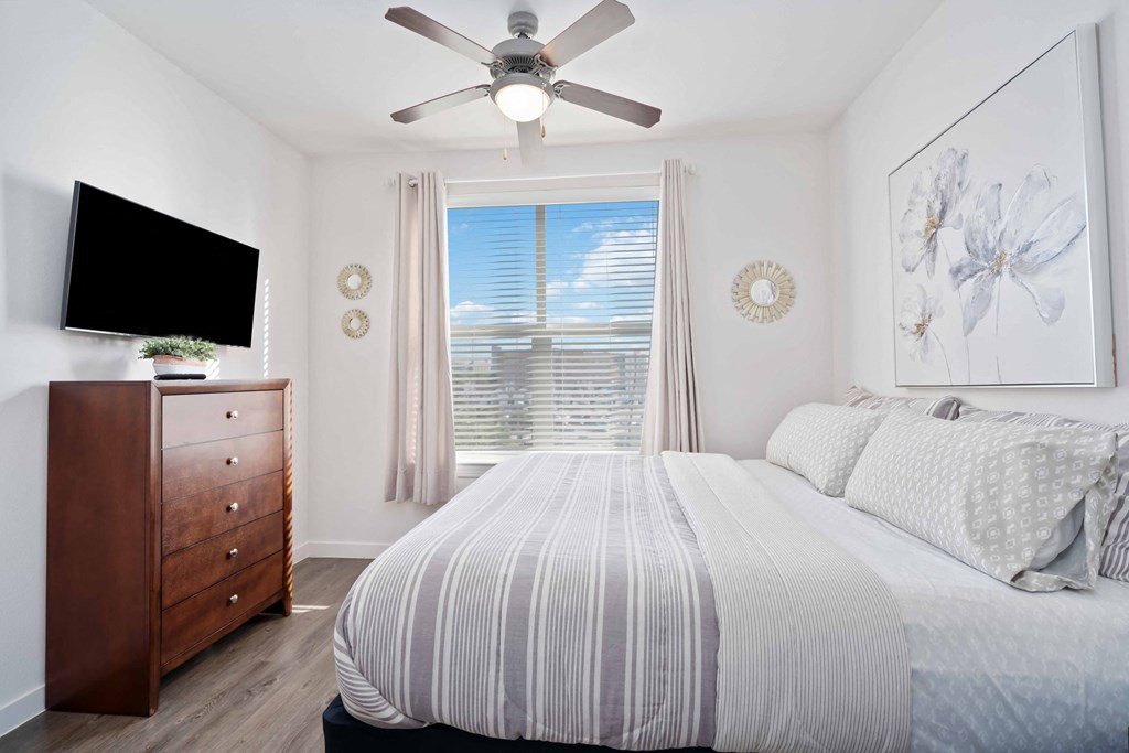 a bedroom with a large bed and a ceiling fan