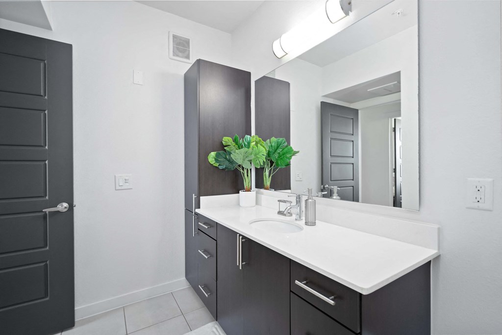 a black and white bathroom with a sink and a mirror