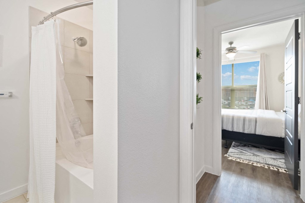 a bathroom with a shower and a bedroom with a bed