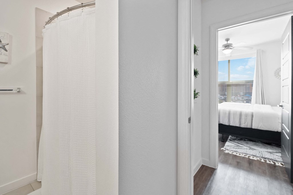 an open door leading into a bedroom with a bed and a mirror