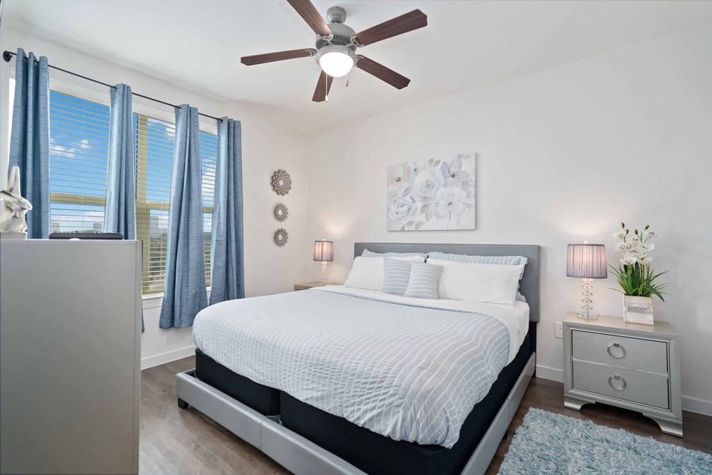 a bedroom with a large bed and a ceiling fan