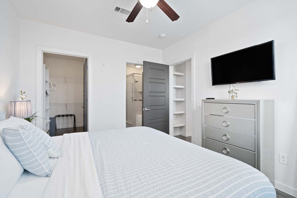 a bedroom with a large bed and a ceiling fan