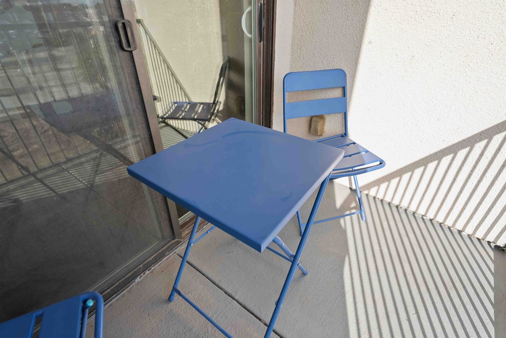 a blue folding table with a blue chair on a balcony