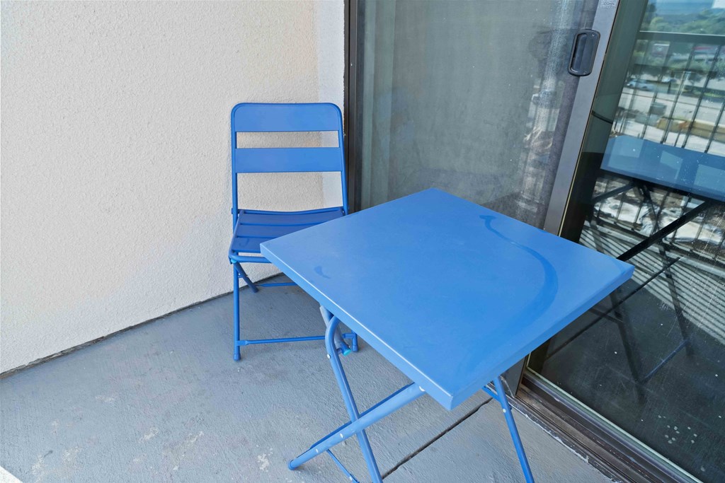a blue table and a blue chair on a balcony