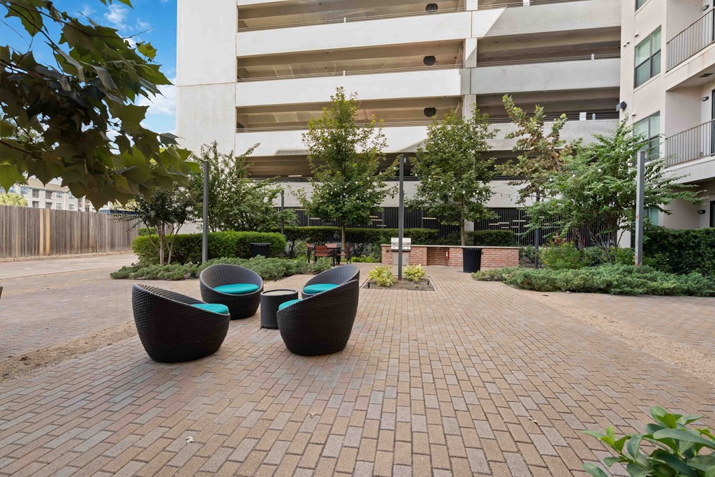 a brick sidewalk with chairs in front of an office building