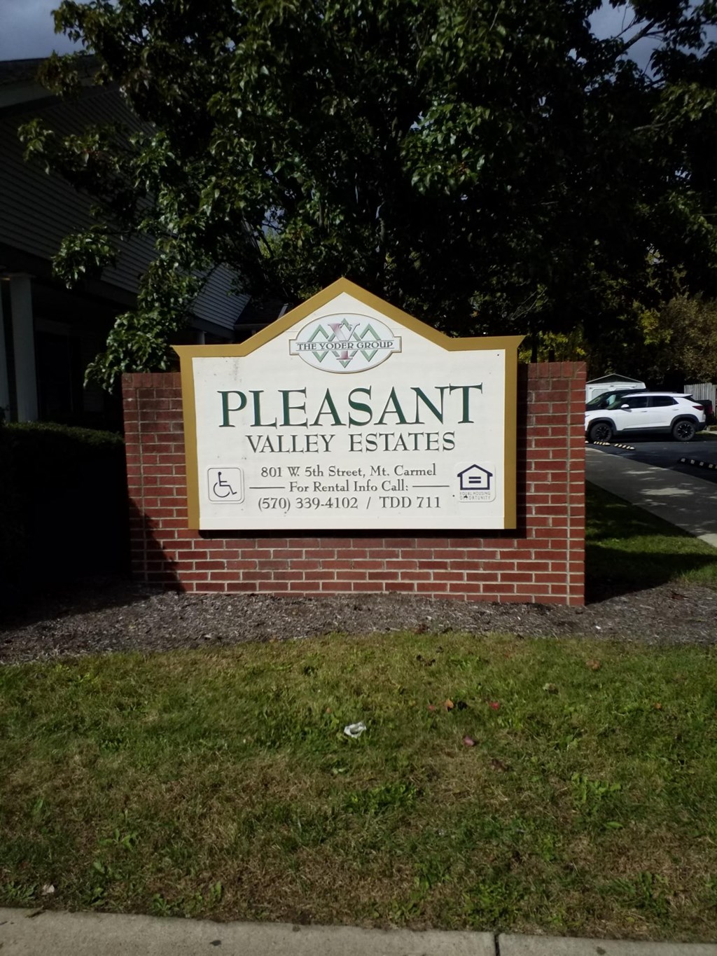 a sign for pleasant valley estates in front of a brick wall