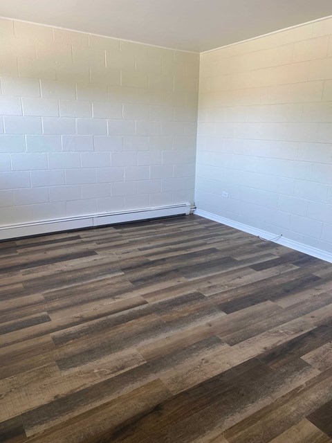a room with wooden floors and white walls