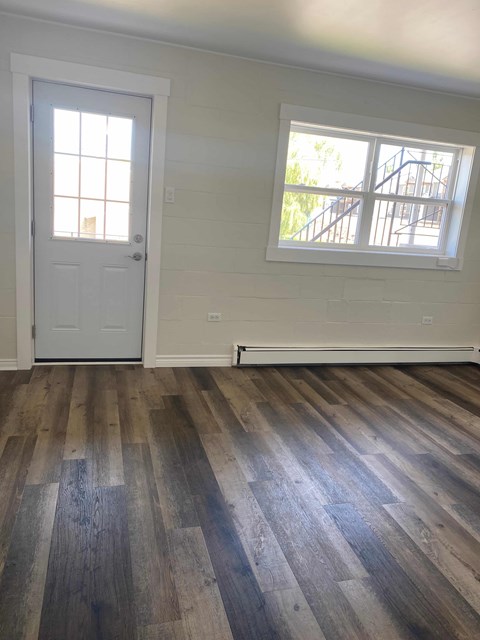 a living room with wood floors and a white door