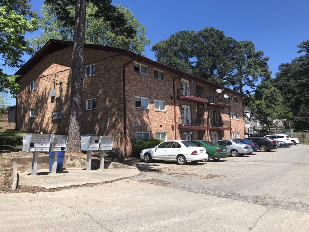 an apartment building with cars parked in front of it