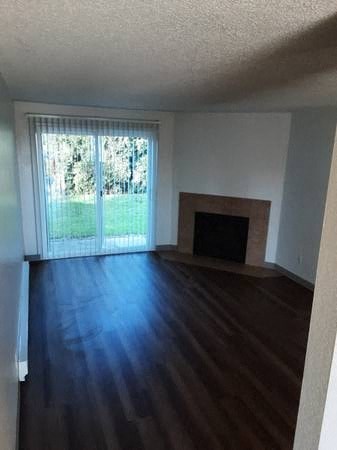 a empty living room with a fireplace and a window