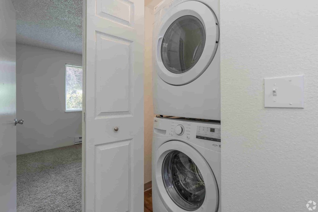 a white washer and dryer in a white laundry room