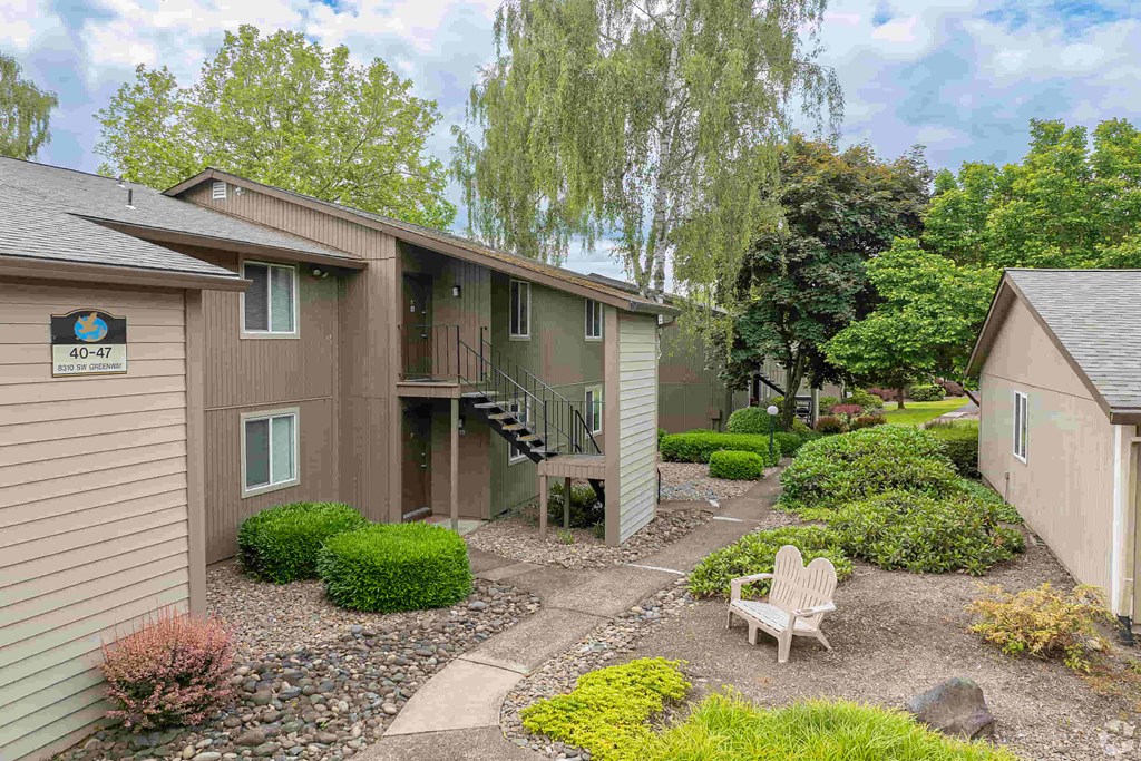 a courtyard with a chair in front of a house