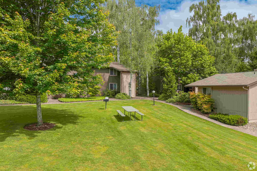 a yard with a picnic table in front of a house
