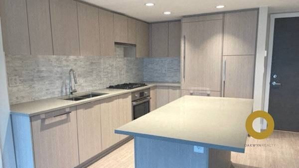 a kitchen with a white counter top and a sink