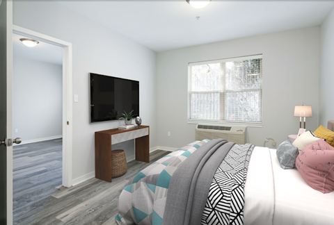 A bedroom with a bed, a television, and a window.