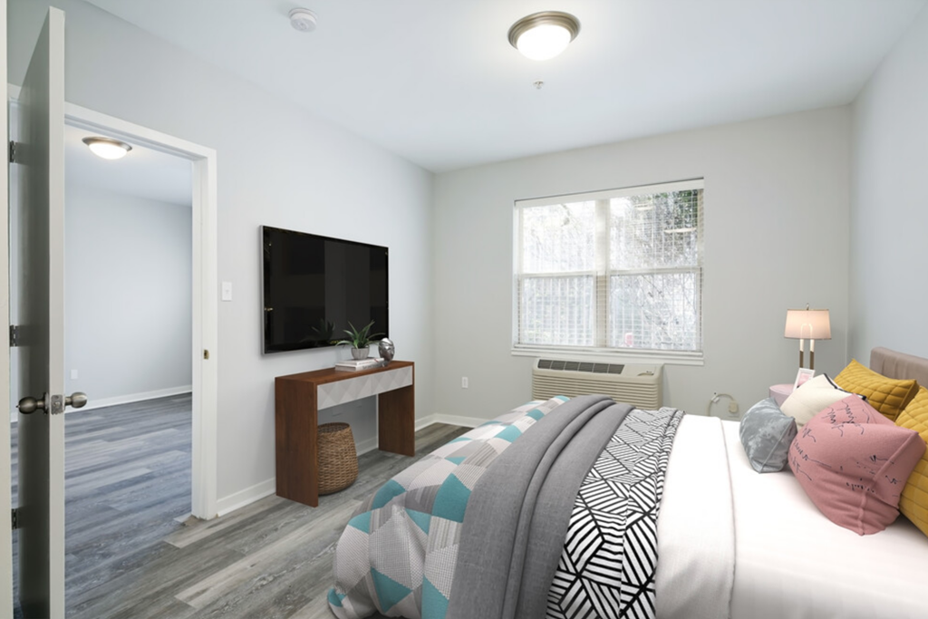 a bedroom with a bed and a tv on the wall