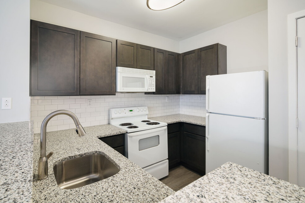 a kitchen with white appliances and granite counter tops