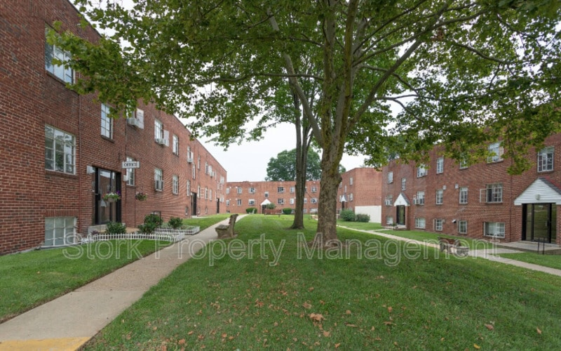 a sidewalk in front of a brick building