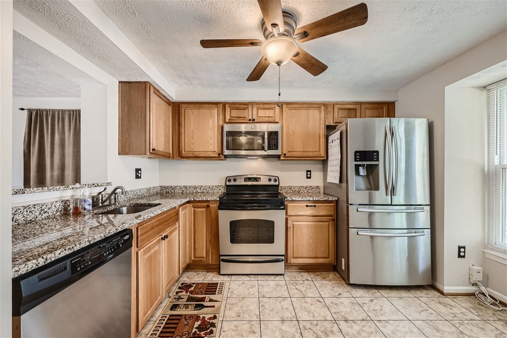 the kitchen is equipped with stainless steel appliances and granite counter tops