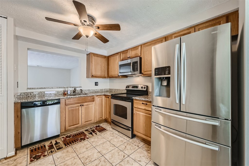 the kitchen has stainless steel appliances and wooden cabinets