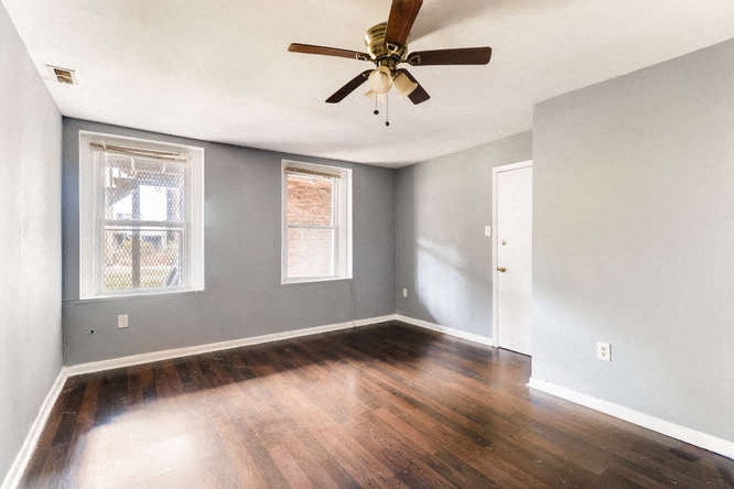 an empty living room with a ceiling fan