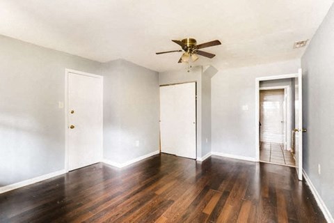 an empty living room with white walls and a ceiling fan