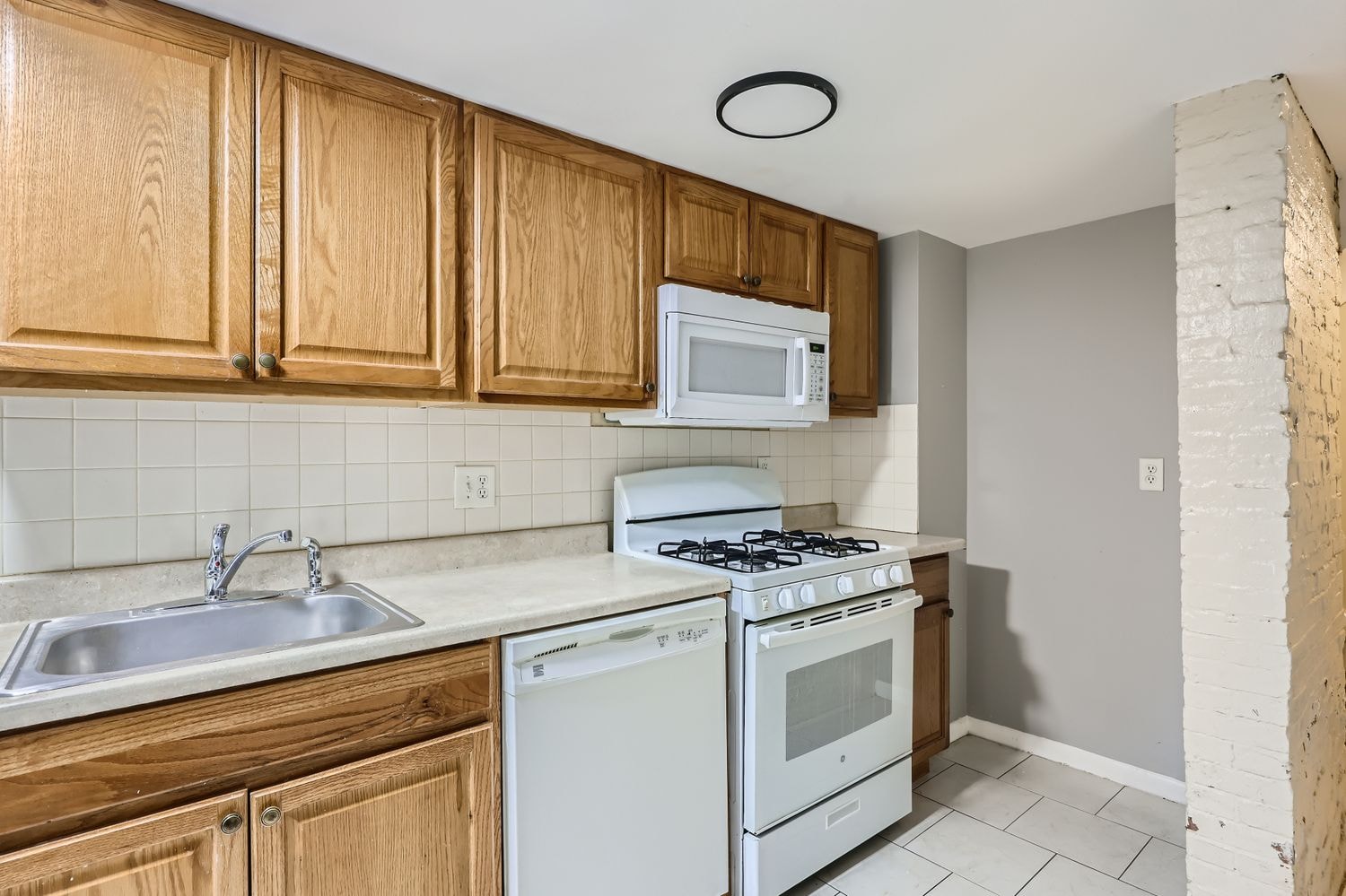 A kitchen with a white stove and a white oven.