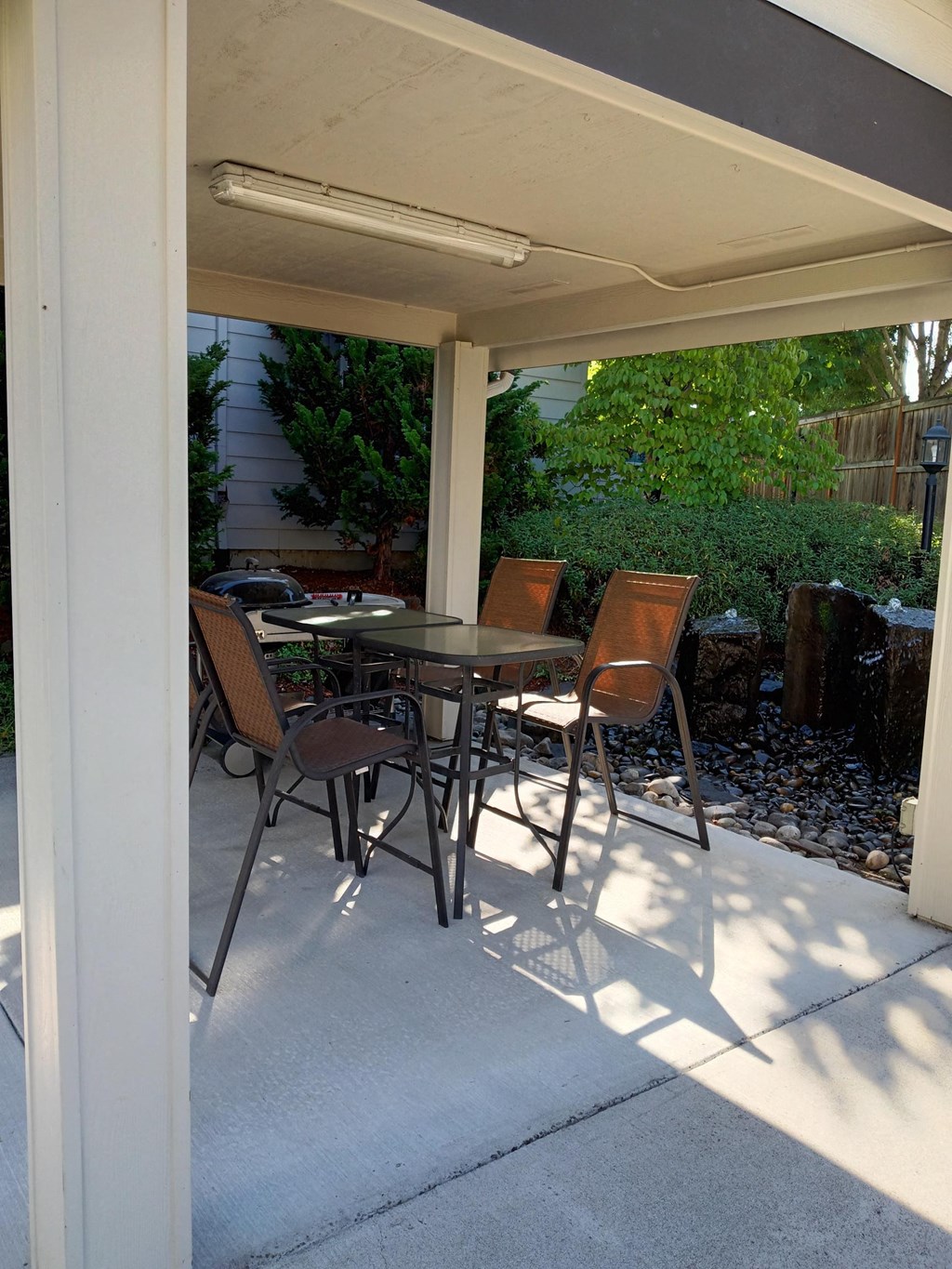 a covered patio with a table and chairs