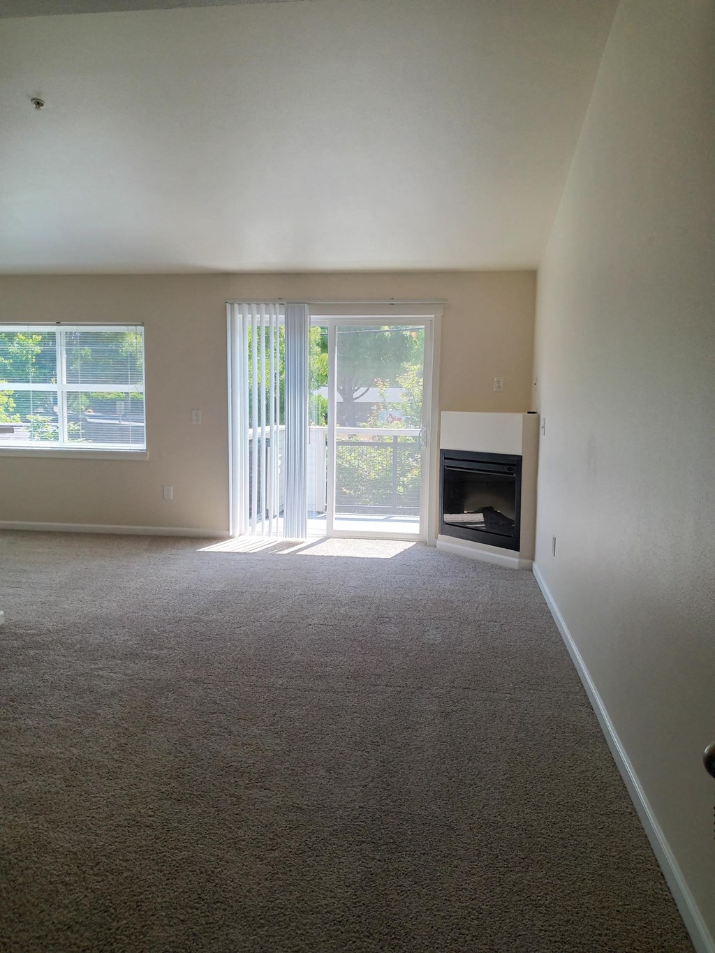 an empty living room with a door to a fireplace