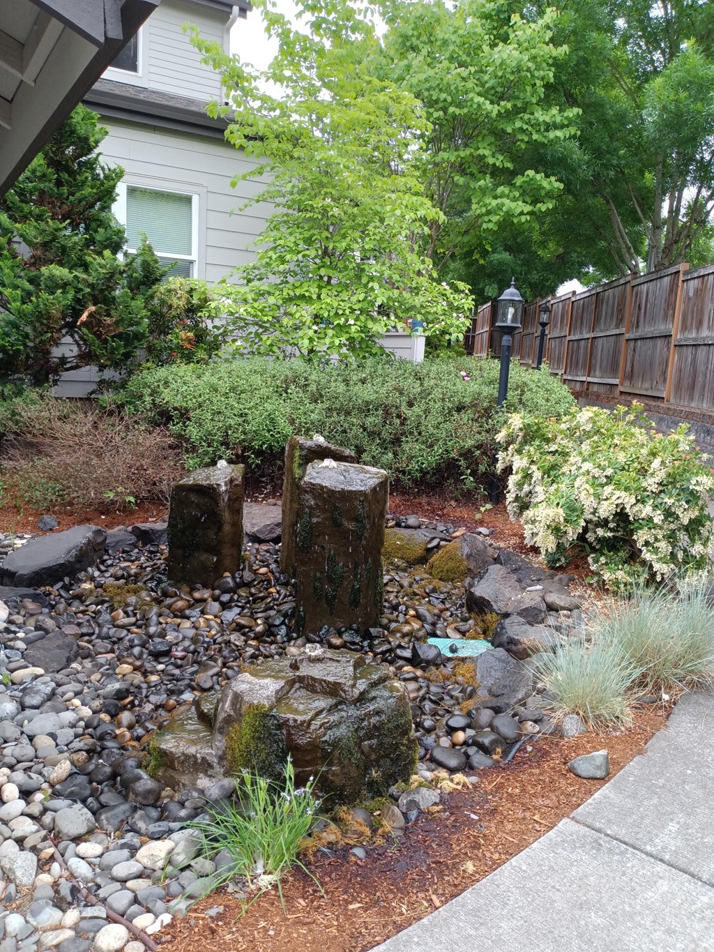 a small waterfall in the backyard of a house
