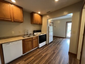 A kitchen with wooden cabinets and a white dishwasher.
