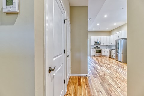 A white door is in a hallway with a wood floor.