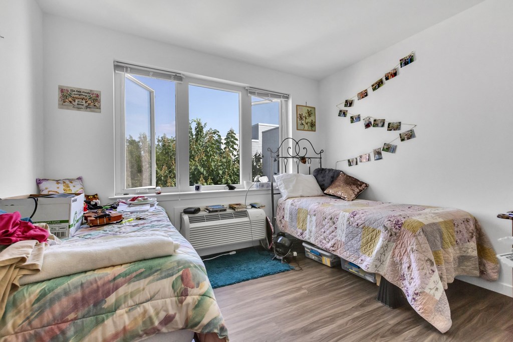 a bedroom with two beds and a large window